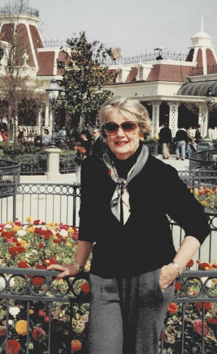 Carol Moss, successful entrepreneur and founder of a charitable foundation, standing near a small flower garden.
