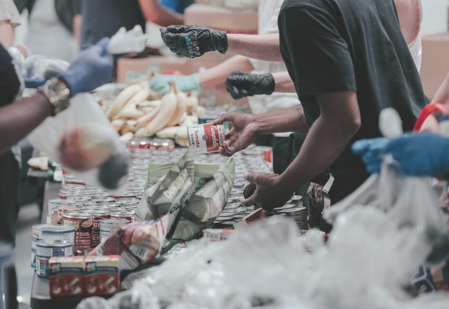 People handing food, cans, fruits for those in need.