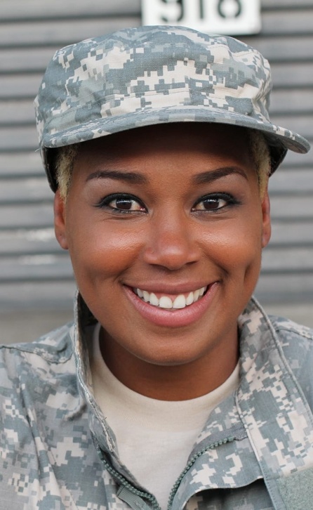 An African American military woman smiling in front of the camera.