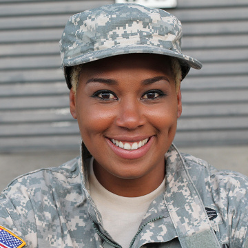 An African American military woman smiling in front of the camera.